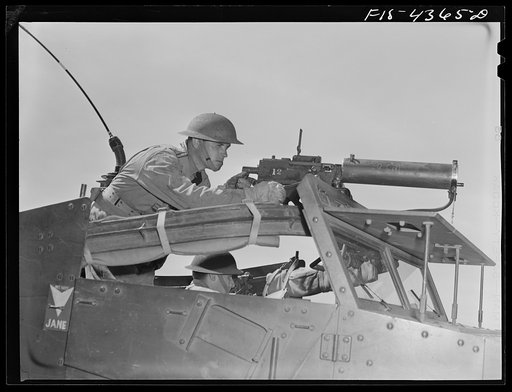 Fort Riley, Kansas. Scout car machine gunner in action during a sham battle