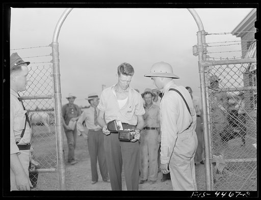 Untitled photo, possibly related to: Sheffield, Alabama (Tennessee Valley Authority (TVA)). Kenneth Hall is inspected by guards as he enters aluminum plant where he works