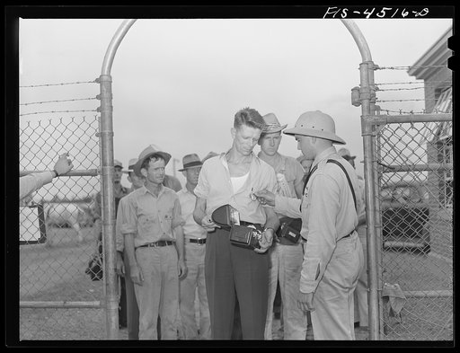 Sheffield, Alabama (Tennessee Valley Authority (TVA)). Kenneth Hall is inspected by guards as he enters aluminum plant where he works