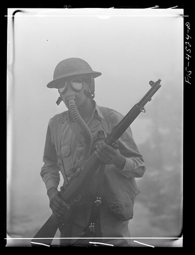 Fort Riley, Kansas. Soldier of a rifle unit going through a smokescreen during a sham battle