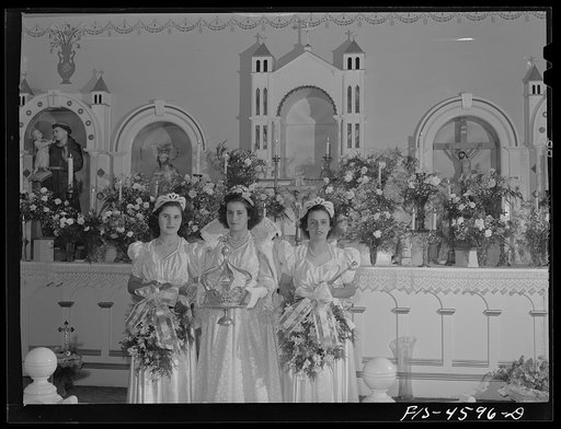 Queen Geraldine Vierra and her maids Margaret Freitas and Lillian Tabash of the fiesta of the Holy Ghost stand in front of the alter in the Sociedade do Espirito Santo (SES) hall, Portuguese-American society which sponsored the fiesta. Santa Clara, California