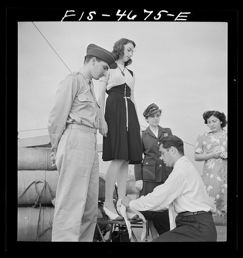 Untitled photo, possibly related to: Washington, D.C. Bandaging an "injured" arm as part of a course in first aid, aboard a Potomac River boat