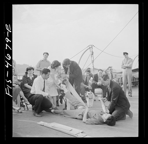 Washington, D.C. Applying a splint to a "broken" leg as part of a course in first aid, aboard a Potomac River boat
