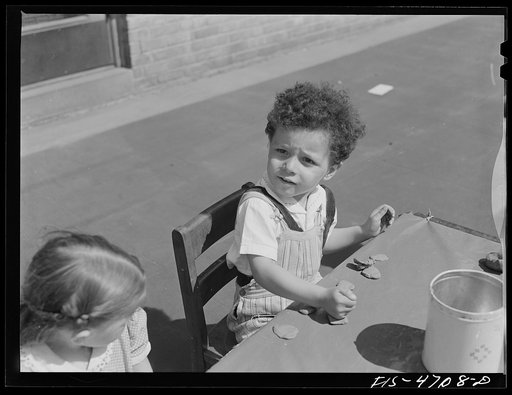 Queens, New York. Child playing with clay at the nursery school at the Queensbridge housing project