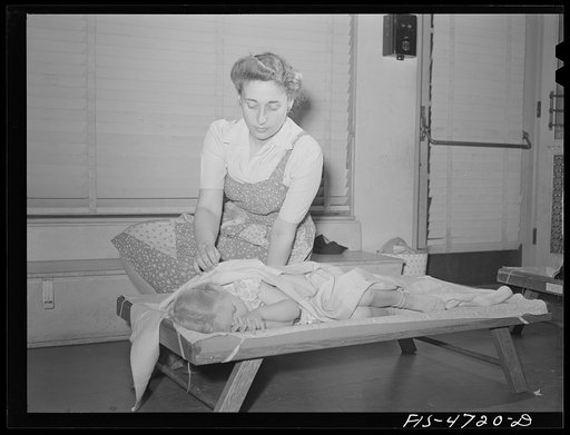 Queens, New York. Nursery worker putting a child to sleep. Nursey school at the Queensbridge housing project