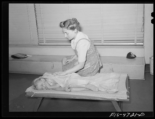 Queens, New York. Nursery school at the Queensbridge housing project. Waking a child after a nap