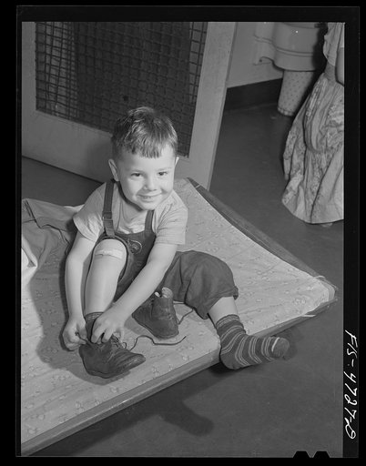 Queens, New York. Nursery school at the Queensbridge housing project. Child dressing after a nap