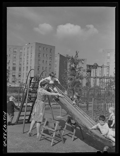 Queens, New York. Nursery worker with children in the playground at the nursery school at the Queensbridge housing project