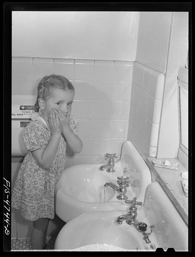 Queens, New York. Nursery school at the Queensbridge housing project. Child washing before lunch
