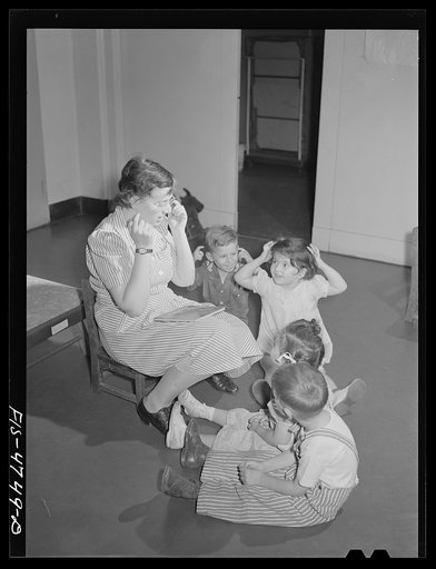 Queens, New York. Nursery school at the Queensbridge housing project. Nursery workers singing with the children