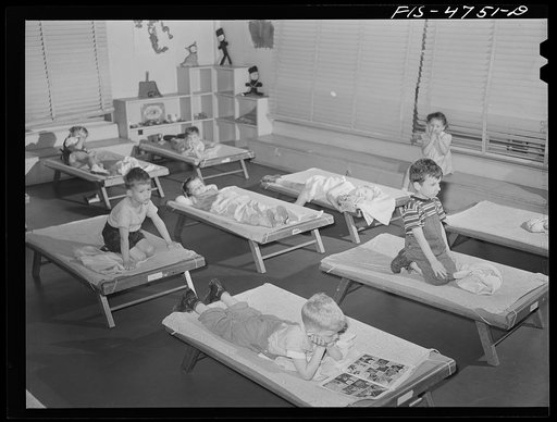 Queens, New York. Nursery school at Queensbridge housing project. Children listening to music during rest period