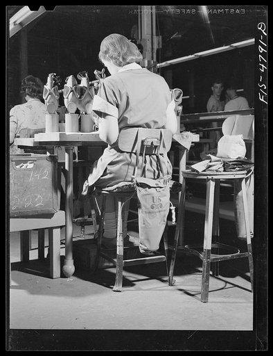 Edgewood Arsenal, Maryland. Gas demonstration. A gas mask hangs on the back of the chair of every worker at the gas mask factory