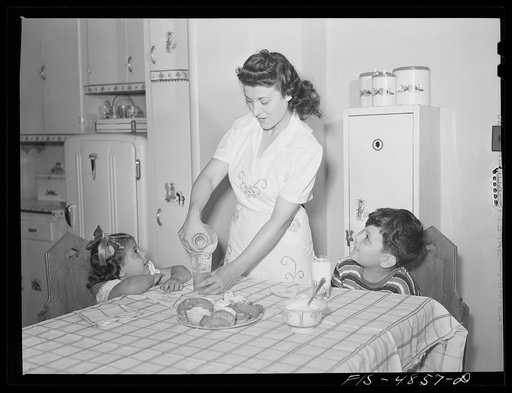 Brooklyn, New York. Red Hook housing development. Mrs. James Caputo in the modern kitchen of her apartment, pouring milk for Annette and Jimmy. The children drink more than a quart apiece daily