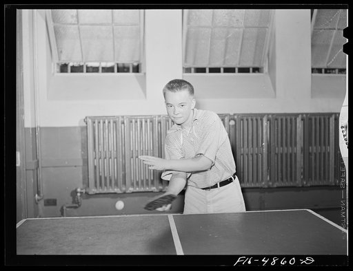 Brooklyn, New York. Red Hook housing development. Boy playing ping-pong in one of the recreation rooms of the community center