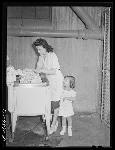 Brooklyn, New York. Red Hook housing development. Mrs. James Caputo using a washing machine. Laundry facilities are available in the basement of every building