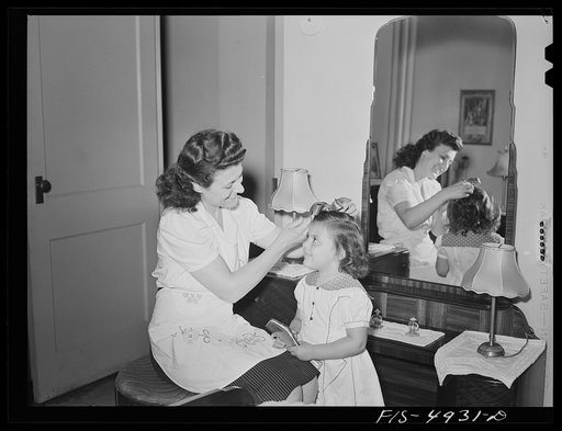 Brooklyn, New York. Red Hook housing project. Mrs. Caputo fixes her three-year-old daughter's hair