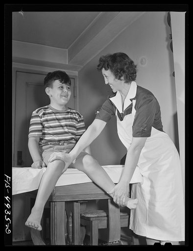 Brooklyn, New York. Red Hook housing project. Jimmy Caputo, who is recovering from infantile paralysis, receiving treatment from nurse sent by visiting nurses' association