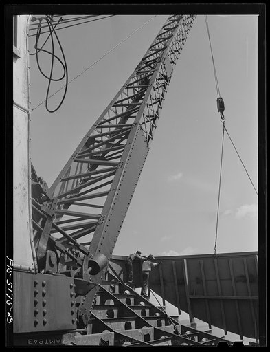 Decatur, Alabama. Ingalls Shipbuilding Company. Derrick lifting one of the sides of the stern of a barge into place for welding