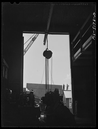 Untitled photo, possibly related to: Decatur, Alabama. Ingalls Shipbuilding Company. One of the barges under construction as seen from the machine shop. In the foreground are engines waiting to be installed in the barge; they will be used to lift the anchor, move cargo, etc.