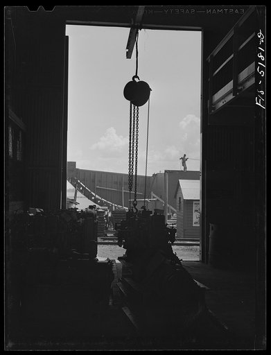 Decatur, Alabama. Ingalls Shipbuilding Company. One of the barges under construction as seen from the machine shop. In the foreground are engines waiting to be installed in the barge; they will be used to lift the anchor, move cargo, etc.