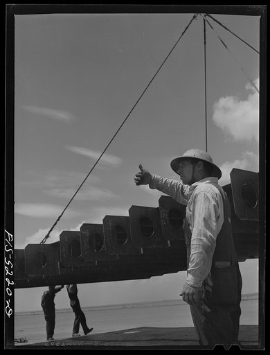 Decatur, Alabama. Ingalls Shipbuilding Company. A section of a ship's bottom being lowered into place. The signal means "boom up"