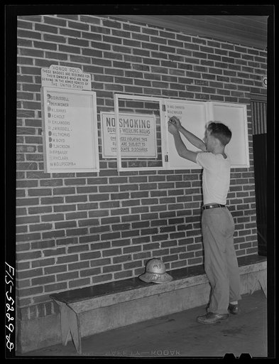 Decatur, Alabama. Ingalls Shipbuilding Company. Morris Black, timekeeper, going off to the army, pinning his badge on the bulletin board carrying the names of other men from the yard who have joined the armed forces