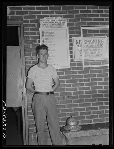 Untitled photo, possibly related to: Decatur, Alabama. Ingalls Shipbuilding Company. Morris Black, timekeeper, going off to the army, pinning his badge on the bulletin board carrying the names of other men from the yard who have joined the armed forces