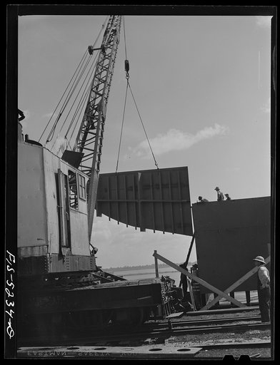 Untitled photo, possibly related to: Decatur, Alabama. Ingalls Shipbuilding Company. Lowering into place one of the sides of the stern of a barge under construction