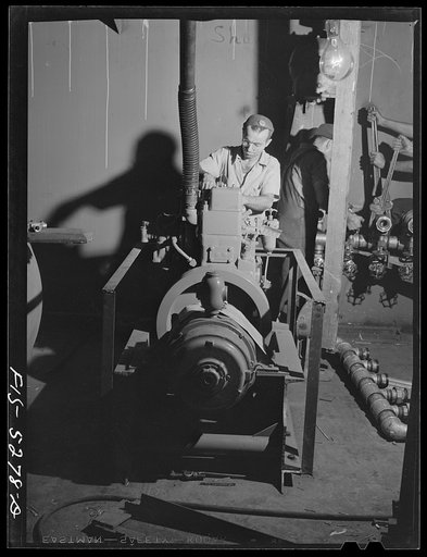 Decatur, Alabama. Ingalls Shipbuilding Company. Installing one of the engines on a barge. The engines are used to lower and raise the anchor, move cargo, run the pumps, etc.