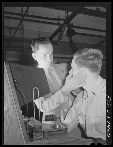 Brooklyn, New York. Doctor examining the eyes of a factory worker