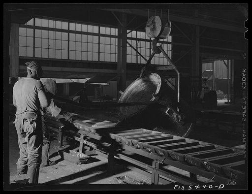 Untitled photo, possibly related to: Sheffield, Alabama. Renolds Metal Company. Pouring liquid aluminum into pig molds from a ladle at the dast house