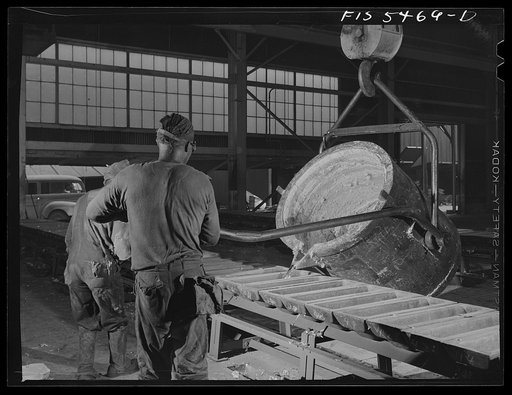 Sheffield, Alabama. Renolds Metal Company. Pouring liquid aluminum into pig molds from a ladle at the dast house