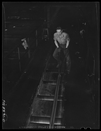 Untitled photo, possibly related to: Sheffield, Alabama. Reynolds Alloys Company. Rolling aluminum rod on the tilt-table in the structural mill