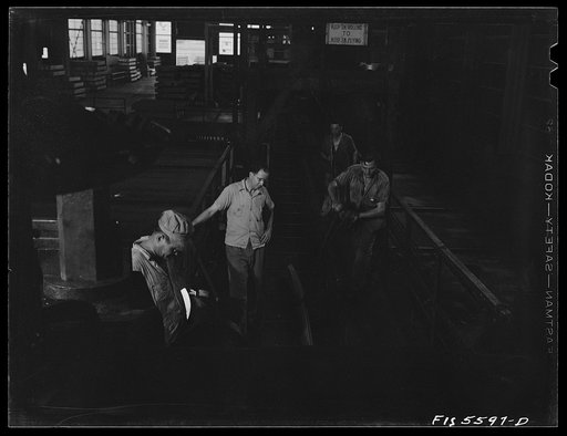 Untitled photo, possibly related to: Sheffield, Alabama. Reynolds Alloys Company. Checking the thickness of aluminum rod being rolled in the structural mill