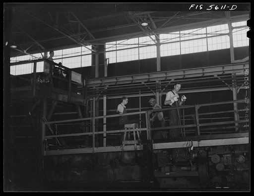 Untitled photo, possibly related to: Sheffield, Alabama. Reynolds Alloys Company. Checking the thickness of aluminum rod being rolled in the structural mill