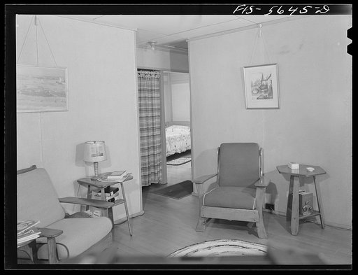 Untitled photo, possibly related to: Middle River, Maryland. Housing development for workers at the Glenn L. Martin aircraft plant. Corner of a living room with wide view of a bedroom showing doorless closet in the hall. The only doors are for the bedrooms