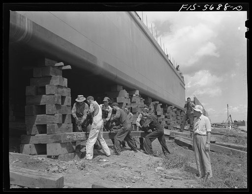 Ingalls Shipbuilding Company, Decatur, Alabama. Removing the timbers which support an Army barge before launching her