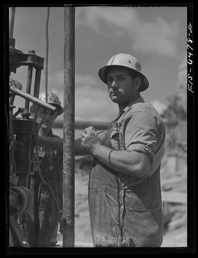 Fort Loudon [i.e., Loudoun] Dam, Tennessee (Tennessee Valley Authority (TVA)). Workman munching a sandwich while operating a drilling machine