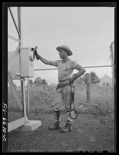 Untitled photo, possibly related to: Hayti, Missouri. U.S. Rural Electrification Administration (REA) lineman inspecting a meter at a substation