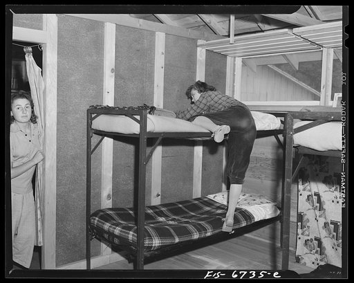 Interlochen, Michigan. National music camp where 300 or more young musicians study symphonic music for eight weeks each summer. Girl getting into an upper deck bed