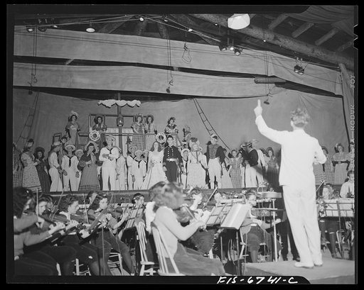 Interlochen, Michigan. National music camp where 300 or more young musicians study symphonic music for eight weeks each summer. Night performance of "Pirates of Penzance" [i.e., H.M.S. Pinafore] by Gilbert and Sullivan