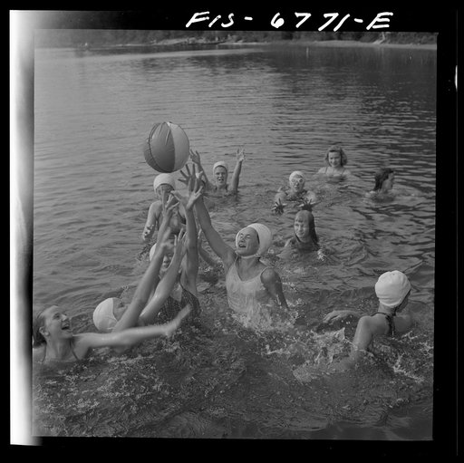 Interlochen, Michigan. National music camp where 300 or more young musicians study symphonic music for eight weeks each summer. Girls playing with large rubber ball in water