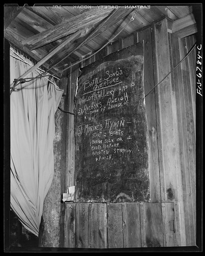 Interlochen, Michigan. National music camp where 300 or more young musicians study symphonic music for eight weeks each summer. Blackboard near bandstand giving directions for a patriotic program