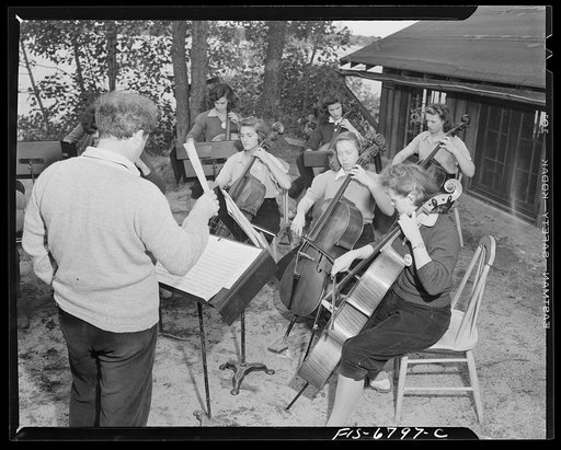 Interlochen, Michigan. National music camp where 300 or more young musicians study symphonic music for eight weeks each summer. Outdoor practice on string instruments