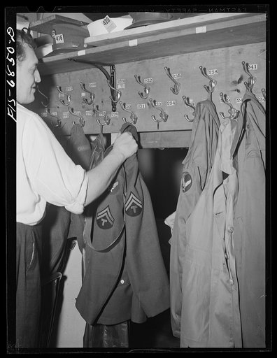 New York, New York. Actor hanging up coats in the coat room at the Stage Door canteen