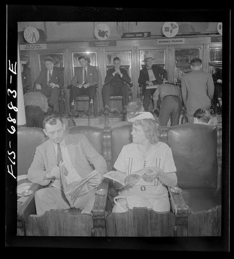 New York, New York. Shoeshine parlor on East Forty-Second Street. Customers in the foreground are waiting while their shoes are repaired