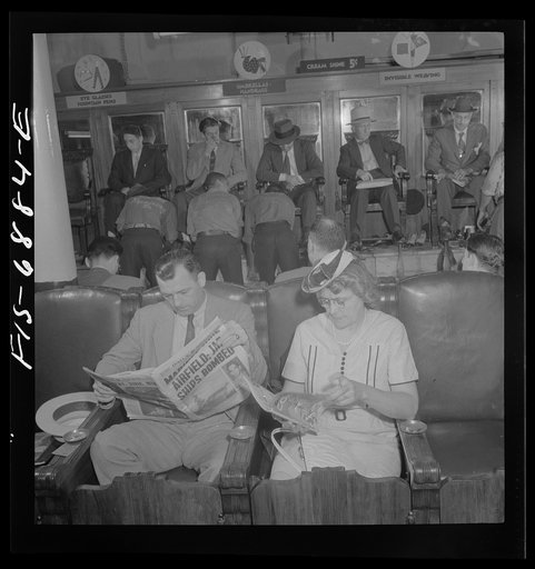 New York, New York. Shoeshine parlor on East Forty-Second Street. Customers in the foreground are waiting while their shoes are repaired