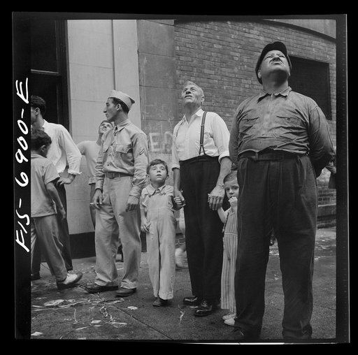 New York, New York. Italian-Americans in the rain watching a flag raising ceremony in honor of the feast of San Rocco at right