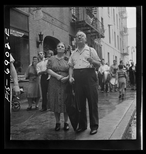 Untitled photo, possibly related to: New York, New York. Italian-Americans in the rain watching a flag raising ceremony in honor of the feast of San Rocco at right