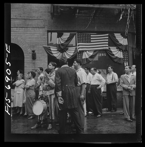 Untitled photo, possibly related to: New York, New York. Italian-Americans in the rain watching a flag raising ceremony in honor of the feast of San Rocco at right